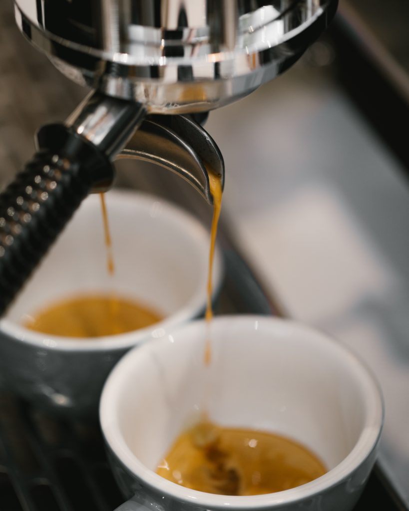 Coffee being poured from a coffee maker into a cup
